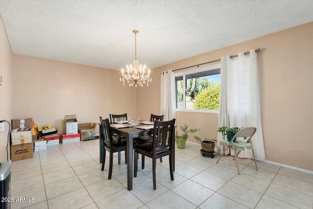 dining space with light tile patterned flooring, an inviting chandelier, and a textured ceiling