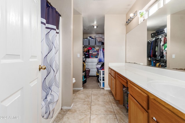 bathroom featuring a shower with curtain, tile patterned flooring, a spacious closet, and vanity