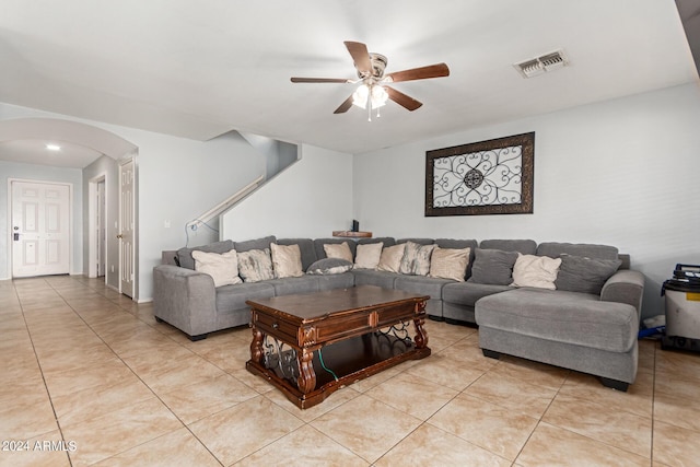 living area with arched walkways, light tile patterned floors, visible vents, and a ceiling fan