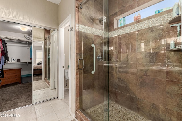 bathroom with toilet, tile patterned floors, and walk in shower