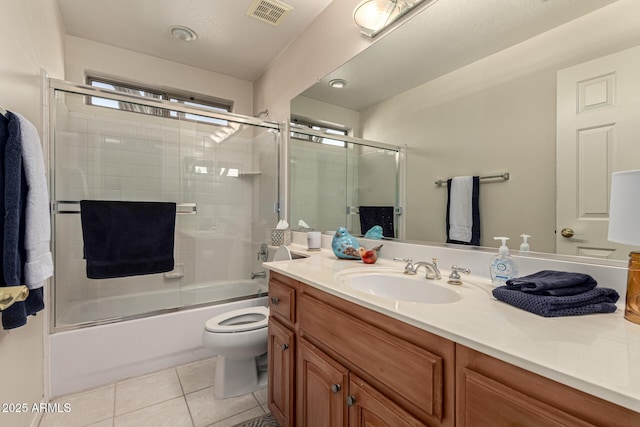 full bathroom featuring enclosed tub / shower combo, vanity, tile patterned floors, and toilet