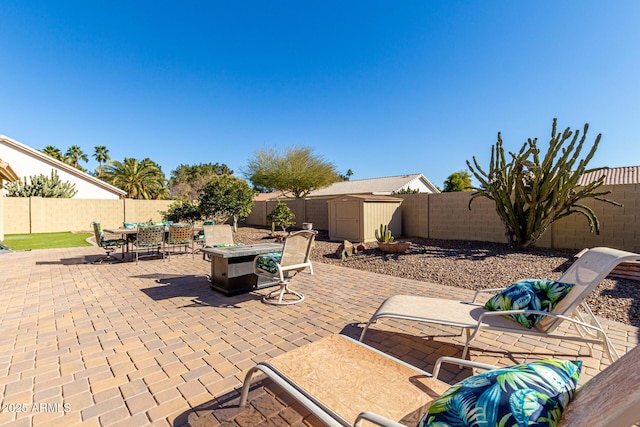 view of patio / terrace with a storage shed and a fire pit