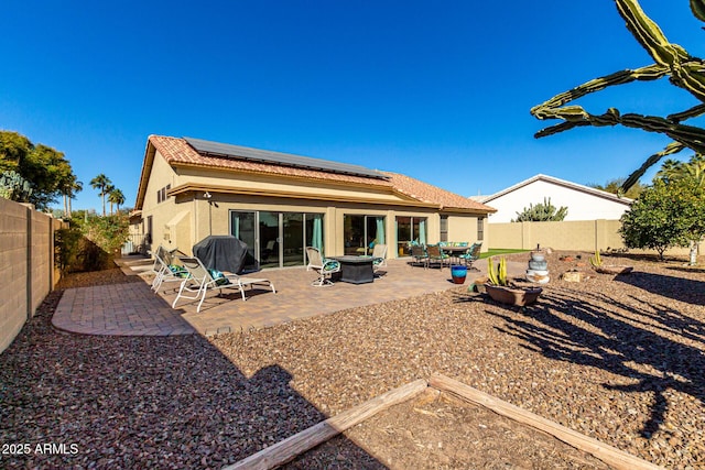 rear view of house featuring a patio area and solar panels