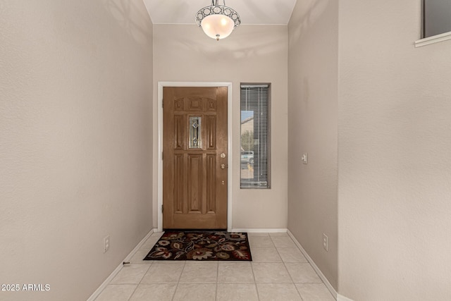 doorway with a high ceiling and light tile patterned floors