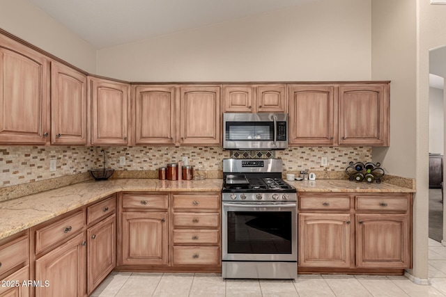 kitchen with stainless steel appliances, lofted ceiling, backsplash, and light stone counters