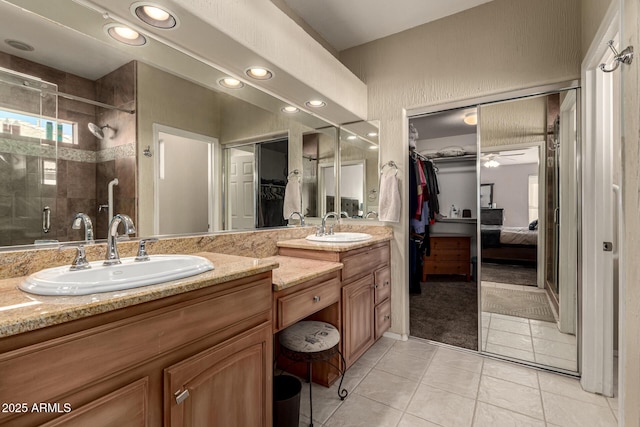 bathroom with tile patterned flooring, vanity, a shower with door, and ceiling fan