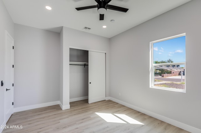 unfurnished bedroom with light hardwood / wood-style flooring, a closet, and ceiling fan