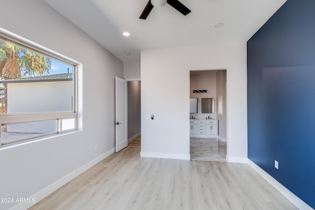 unfurnished bedroom featuring light hardwood / wood-style flooring, ensuite bath, and ceiling fan