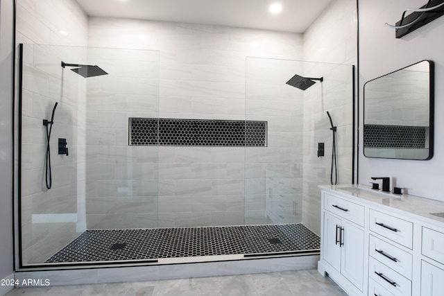 bathroom featuring tiled shower and vanity