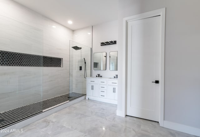 bathroom with a tile shower and vanity