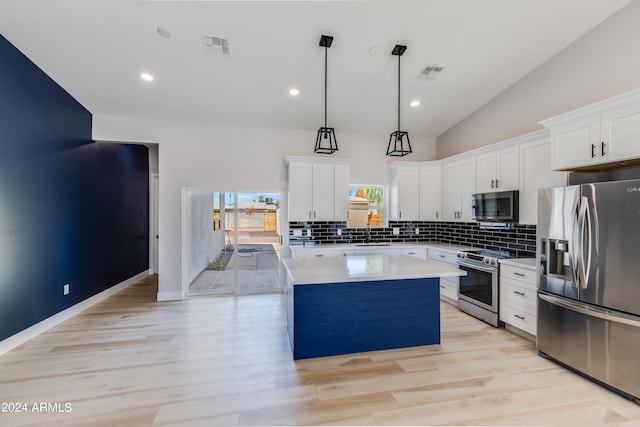 kitchen featuring decorative light fixtures, stainless steel appliances, light hardwood / wood-style floors, and white cabinetry