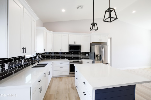 kitchen with sink, decorative light fixtures, stainless steel appliances, a center island, and light hardwood / wood-style floors