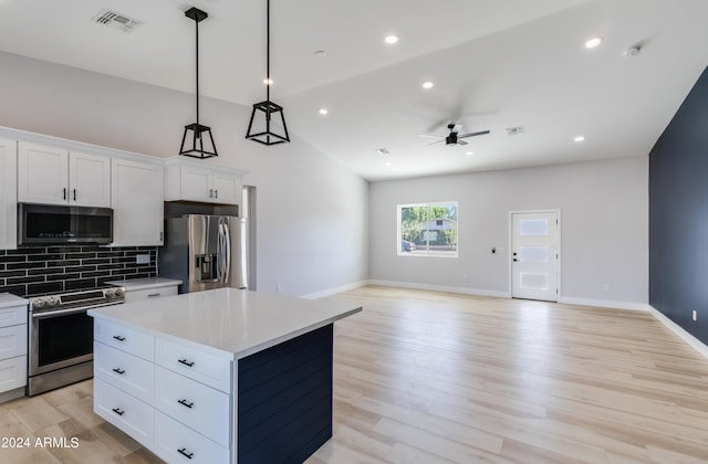 kitchen featuring white cabinetry, a kitchen island, stainless steel appliances, lofted ceiling, and ceiling fan