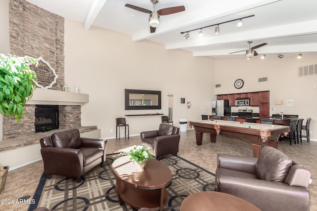 living room featuring track lighting, pool table, beamed ceiling, a fireplace, and ceiling fan