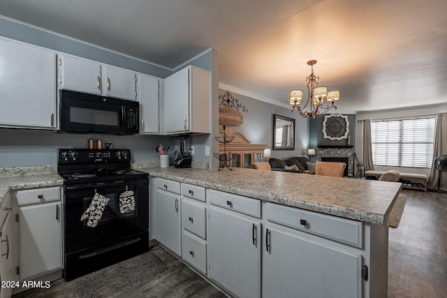 kitchen featuring black appliances, a fireplace, kitchen peninsula, hanging light fixtures, and dark hardwood / wood-style floors