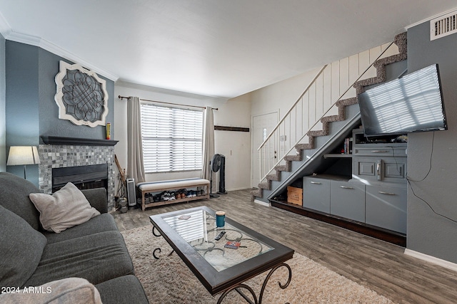 living room with crown molding, hardwood / wood-style flooring, and a fireplace