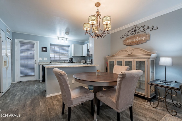 dining area featuring crown molding, dark hardwood / wood-style floors, and a chandelier