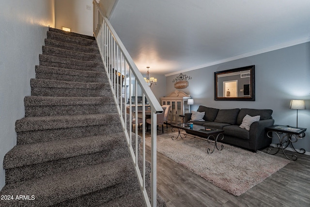 staircase featuring ornamental molding, a notable chandelier, and hardwood / wood-style flooring