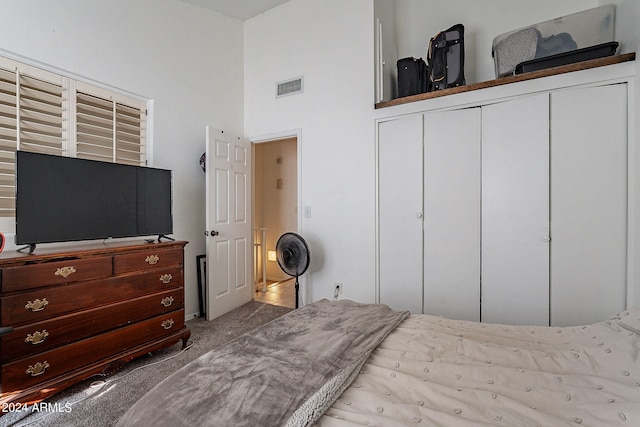 bedroom with a towering ceiling, light carpet, and a closet