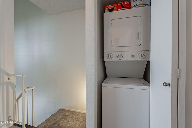 clothes washing area with stacked washer and clothes dryer, a textured ceiling, and carpet floors