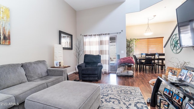 living room featuring dark hardwood / wood-style flooring and a towering ceiling