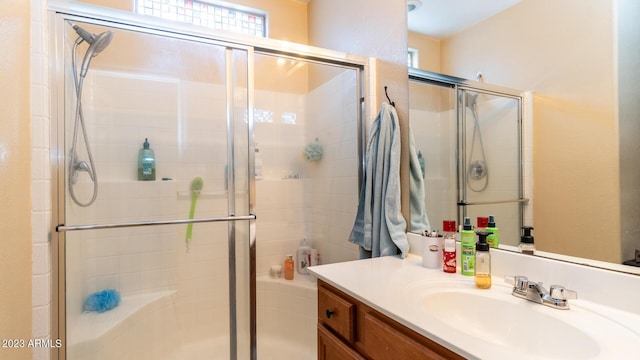 bathroom with a shower with door and vanity