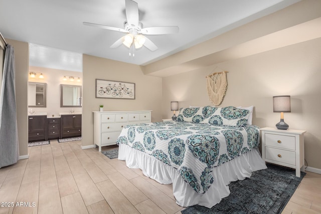 bedroom featuring ceiling fan, sink, light hardwood / wood-style floors, and ensuite bath