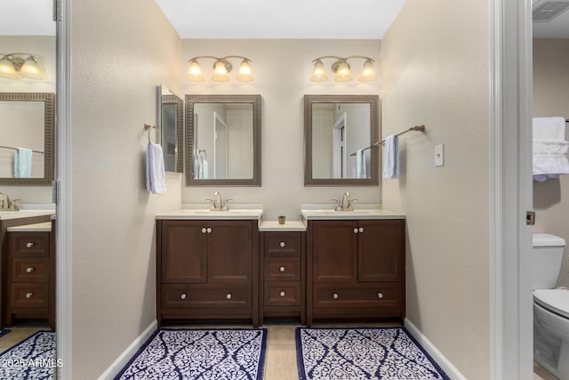 bathroom with tile patterned flooring, vanity, and toilet