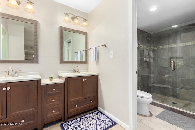 bathroom with a shower with door, vanity, tile patterned flooring, and toilet