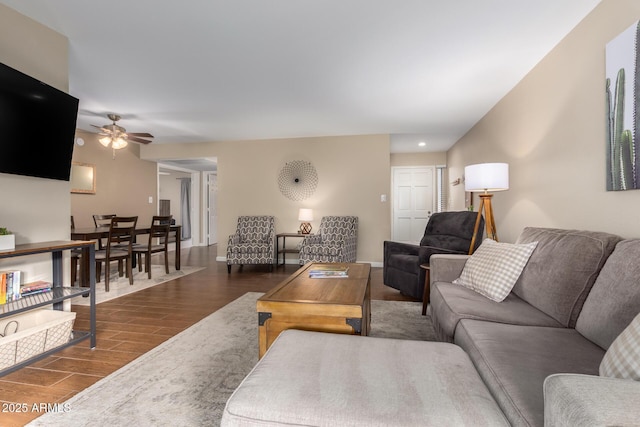 living room featuring dark wood-type flooring and ceiling fan