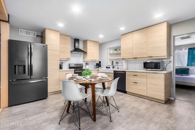 kitchen featuring appliances with stainless steel finishes, wall chimney exhaust hood, backsplash, and light brown cabinets