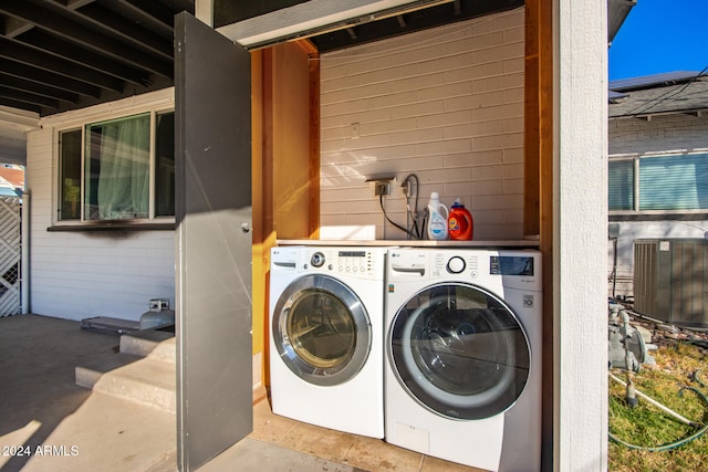 clothes washing area with washing machine and dryer