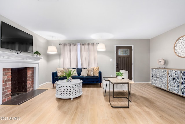 living room featuring wood-type flooring and a brick fireplace