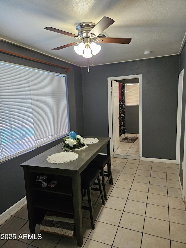 4507 E Saint Catherine Ave, Phoenix, AZ 85042 - dining area with light tile patterned flooring, a ceiling fan, baseboards, and a textured ceiling