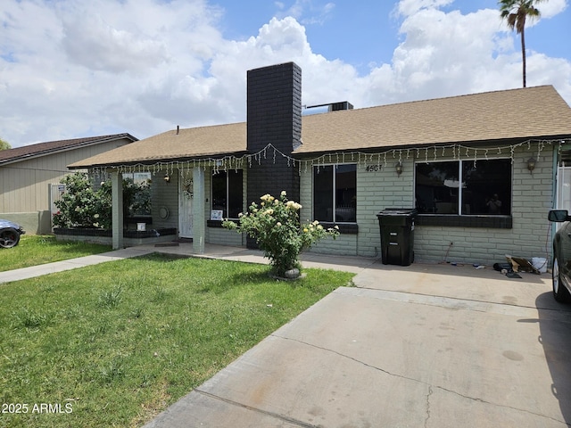 4507 E Saint Catherine Ave, Phoenix, AZ 85042 - ranch-style home with a chimney, a front lawn, brick siding, and a shingled roof