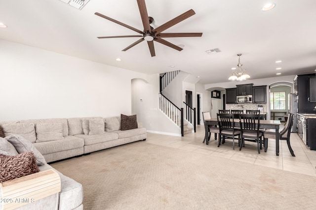 20709 W Delaney Dr, Buckeye, AZ 85396 - living area featuring arched walkways, light tile patterned floors, a ceiling fan, stairs, and recessed lighting