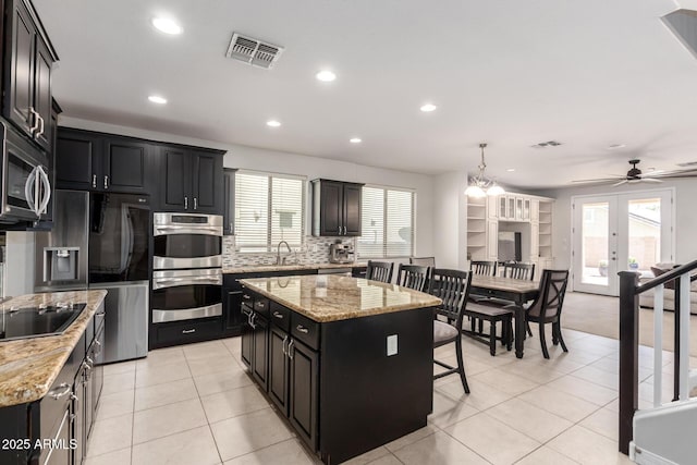 20709 W Delaney Dr, Buckeye, AZ 85396 - kitchen featuring stainless steel appliances, dark cabinetry, recessed lighting, a kitchen island, and a ceiling fan