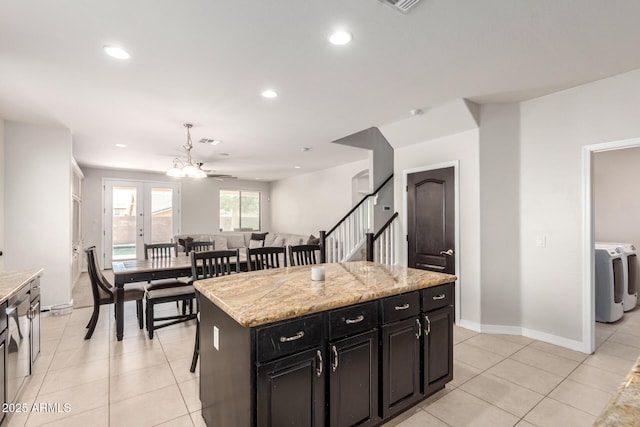 20709 W Delaney Dr, Buckeye, AZ 85396 - kitchen featuring washer and clothes dryer, dark cabinets, recessed lighting, light tile patterned flooring, and a kitchen island