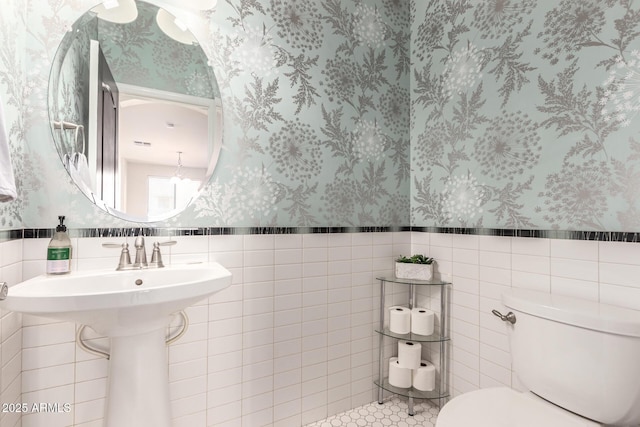 20709 W Delaney Dr, Buckeye, AZ 85396 - half bath with wallpapered walls, tile walls, wainscoting, and a chandelier