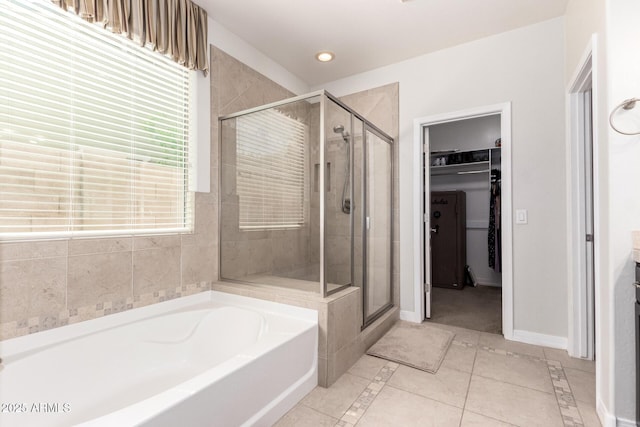 20709 W Delaney Dr, Buckeye, AZ 85396 - bathroom with a stall shower, a bath, a walk in closet, inlaid floor details, and tile patterned flooring