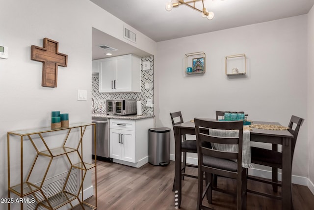 kitchen featuring tasteful backsplash, white cabinets, visible vents, and stainless steel dishwasher