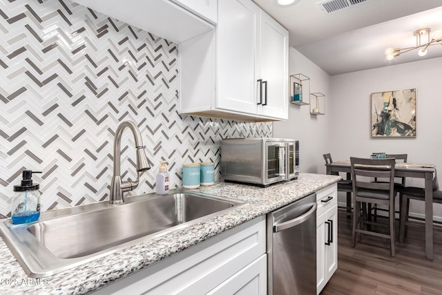 kitchen with sink, white cabinetry, backsplash, dark hardwood / wood-style flooring, and stainless steel dishwasher