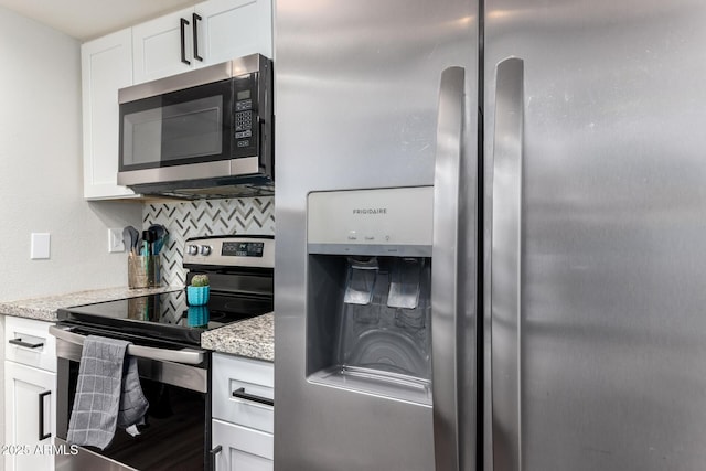 kitchen with stainless steel appliances, white cabinets, decorative backsplash, and light stone countertops