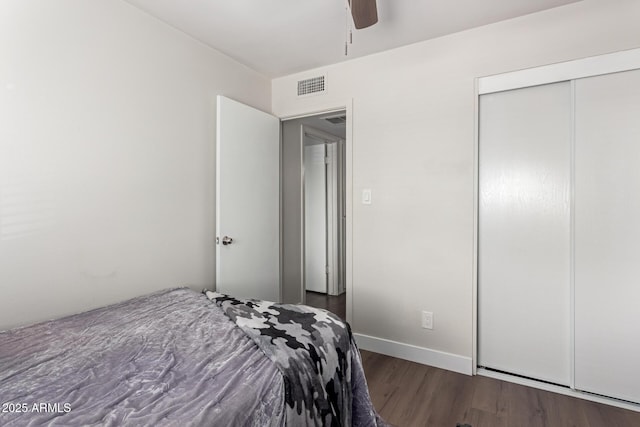 bedroom featuring dark wood-type flooring, ceiling fan, and a closet