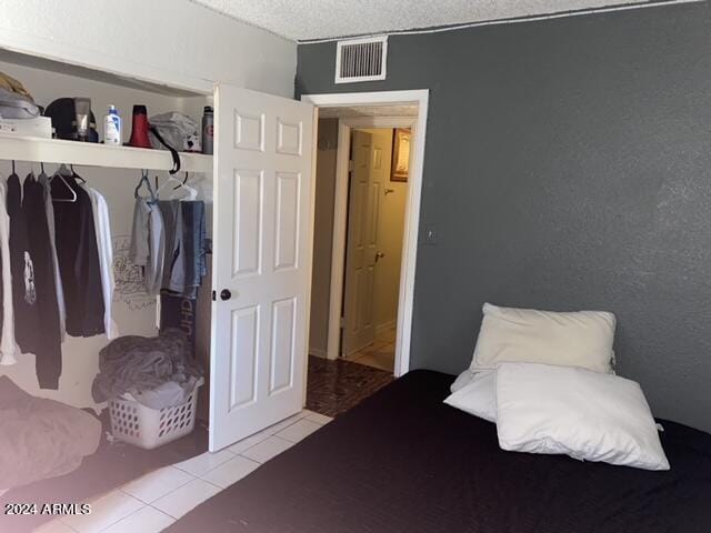 bedroom with light tile patterned floors and a textured ceiling