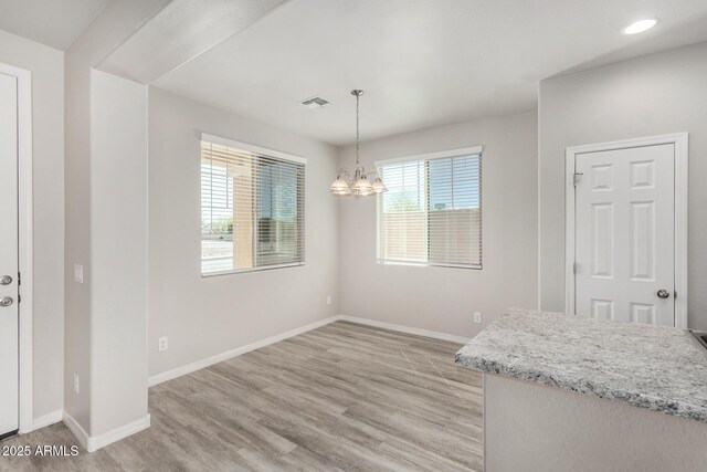 810 E Agua Fria Ln, Avondale, AZ 85323 - unfurnished dining area featuring baseboards, light wood-type flooring, visible vents, and an inviting chandelier
