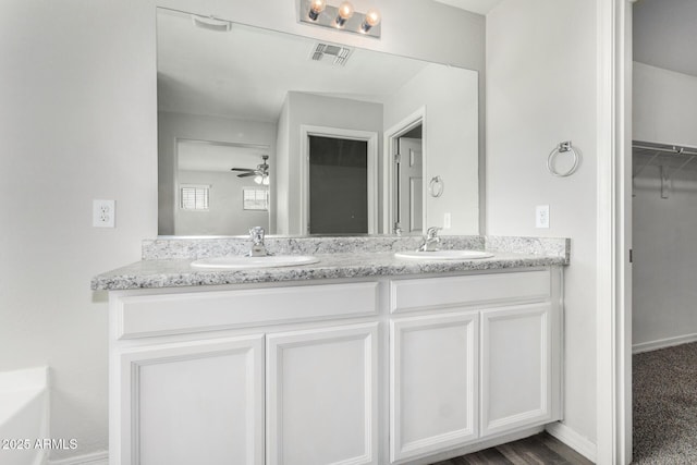 810 E Agua Fria Ln, Avondale, AZ 85323 - full bath featuring double vanity, visible vents, a sink, and a walk in closet