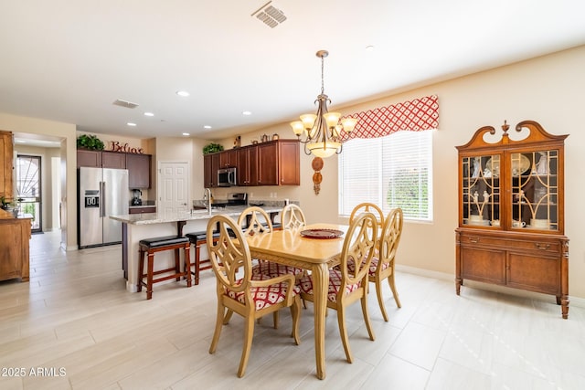 dining room with a chandelier and sink