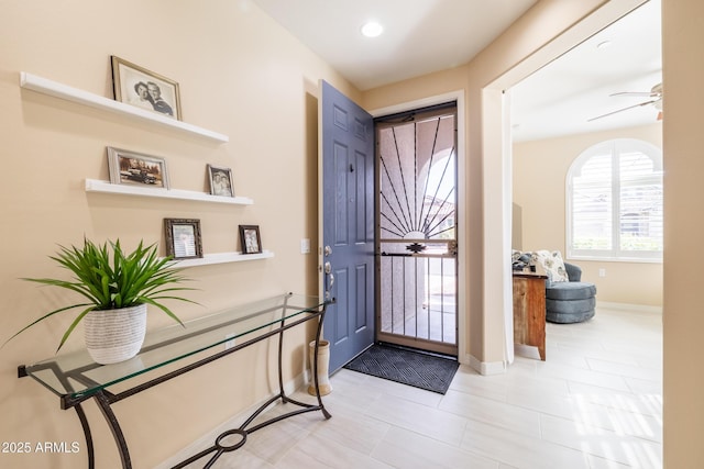 tiled foyer featuring ceiling fan