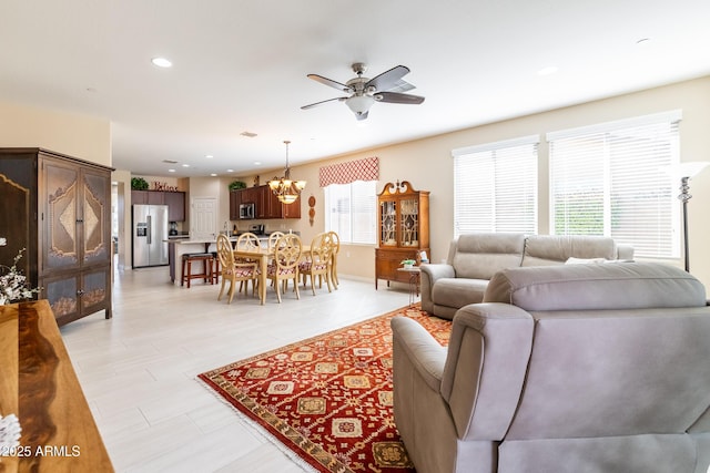 living room featuring ceiling fan with notable chandelier